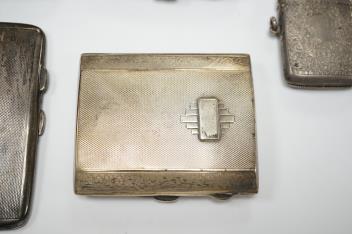 Three assorted silver cigarette cases including Art Deco, largest 10.1cm, a silver vesta case and a white metal cigarette case.